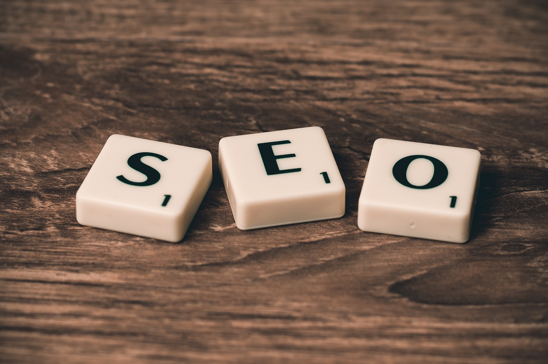 SEO Tiles three scrabble letters spelling SEO placed on a brown wooden table top
